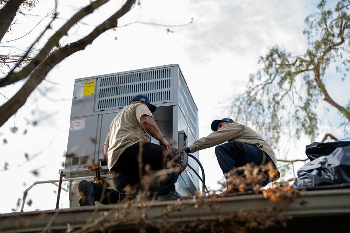 two technicians installing an AC Unit