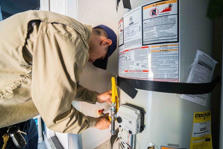 A technician repairing a water heater